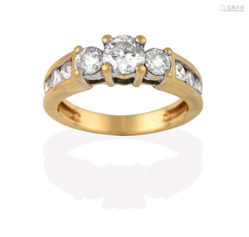 A Diamond Three Stone Ring, the graduated round brilliant cut diamonds in yellow claw settings, to a