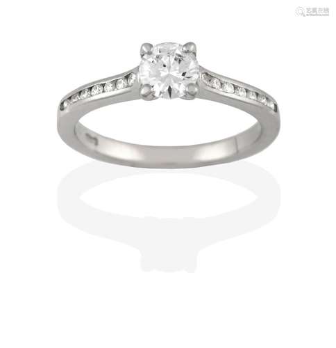 A Platinum Diamond Solitaire Ring, the round brilliant cut diamond in a claw setting, to a channel