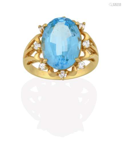 An 18 Carat Gold Blue Topaz and Diamond Cluster Ring, the oval cut blue topaz within a spaced border