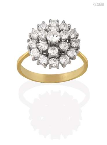 An 18 Carat Gold Diamond Cluster Ring, the round brilliant cut diamond within a double stepped