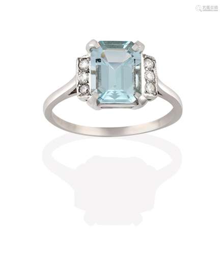 An Aquamarine and Diamond Ring, the emerald-cut aquamarine in a white claw setting, flanked by trios