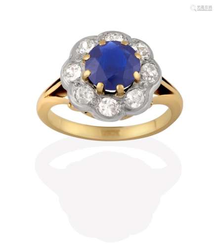 A Sapphire and Diamond Cluster Ring, the round cut sapphire in yellow claw settings, within a border