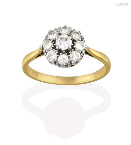 A Diamond Cluster Ring, the central raised round brilliant cut diamond within a border of smaller