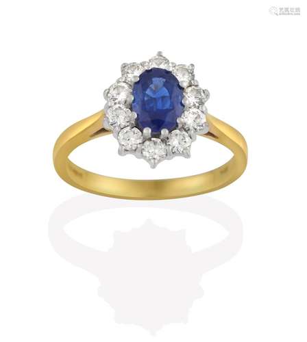 An 18 Carat Gold Sapphire and Diamond Cluster Ring, the oval cut sapphire within a border of round