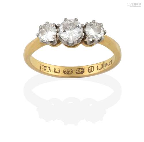 A 22 Carat Gold Diamond Three Stone Ring, the graduated round brilliant cut diamonds in white claw