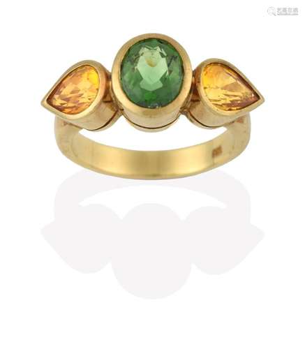 A Green Tourmaline and Yellow Sapphire Three Stone Ring, the central oval cut green tourmaline