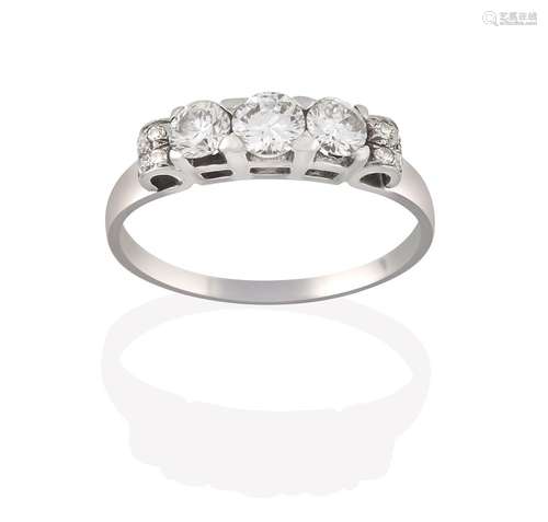 A Diamond Three Stone Ring, the graduated round brilliant cut diamonds in white claw settings, to