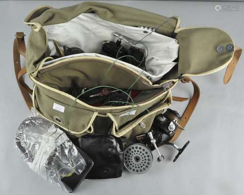 A plastic lined canvas fishing bag with two Mitchell fly reels, spare spools,