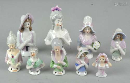 A collection of assorted ceramic pin cushion ladies, largest 9cm high,