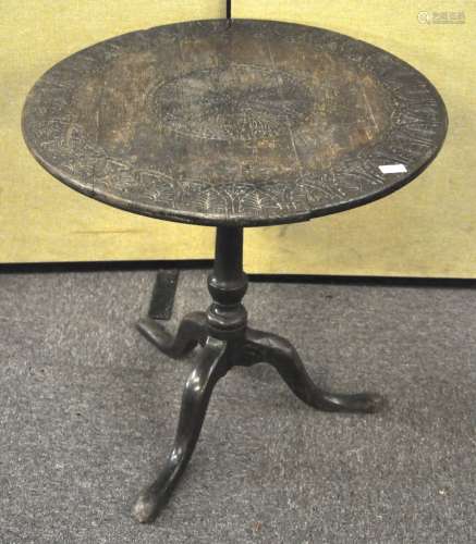 An early 19th century circular tilt top table with later carved decoration,