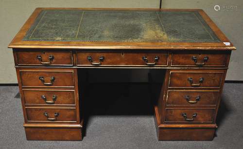 A reproduction twin pedestal desk with green leather top and three frieze drawers,