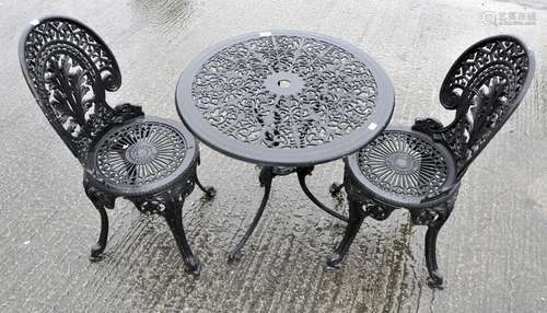 A cast aluminium painted black garden table and chairs,