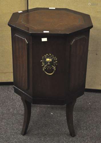 A mahogany side table with leather top and decorative handle,