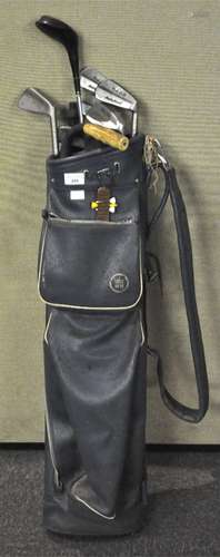 A golf bag together with some vintage clubs