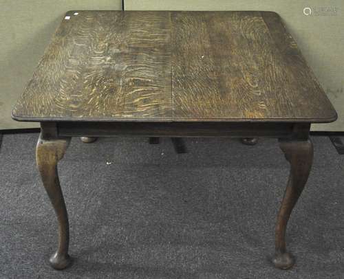 An oak wind out dining table on cabriole legs,