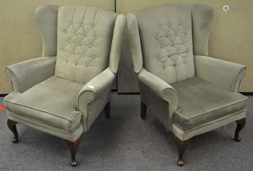 A pair of period style wing armchairs with mahogany legs,
