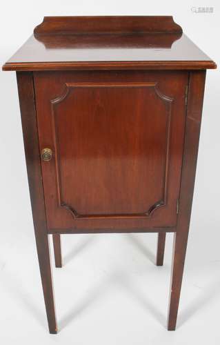 An Edwardian style pot cupboard, of plain form, with panel door, raised on slightly tapered legs,