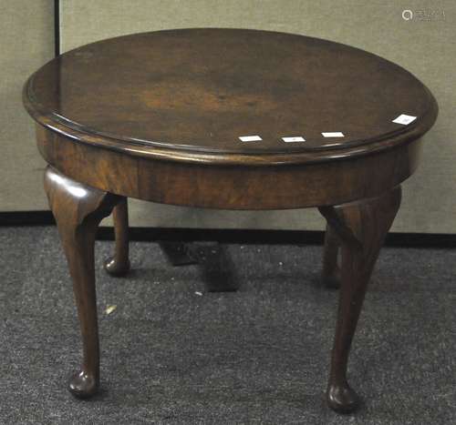 A 20th century round walnut sofa table on cabriole legs.