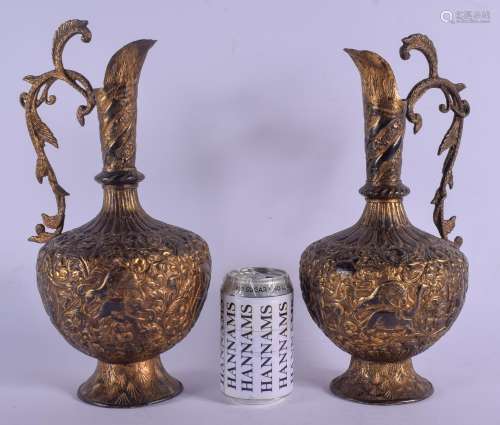 A PAIR OF EARLY 19TH CENTURY MIDDLE EASTERN TINNED BRASS EWERS decorated with buddhistic figures and