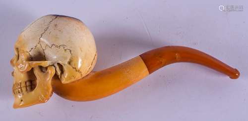 A 19TH CENTURY CARVED MEERSCHAUM AND AMBER PIPE formed as a skull. 15 cm wide.