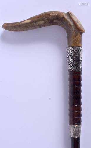 A 19TH CENTURY CONTINENTAL CARVED RHINOCEROS HORN WALKING CANE with silver mounts. 88 cm long.