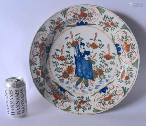 A LARGE EARLY 18TH CENTURY DUTCH DELFT FAIENCE TIN GLAZED DISH painted with a female in blue holding