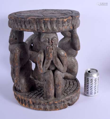 AN EARLY 20TH CENTURY AFRICAN YORUBA TRIBAL STOOL formed with four opposing figures. 38 cm x 26 cm.