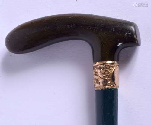 A 19TH CENTURY CONTINENTAL CARVED RHINOCEROS HORN WALKING CANE with gold mounts. 88 cm long.