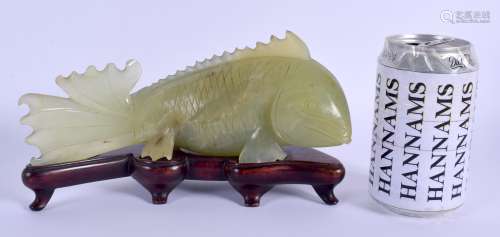 AN EARLY 20TH CENTURY CHINESE CARVED JADE FIGURE OF A FISH Late Qing, modelled upon a fitted hardwoo