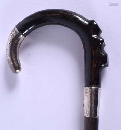 A 19TH CENTURY CONTINENTAL CARVED RHINOCEROS HORN WALKING CANE with silver mounts. 67 cm long.