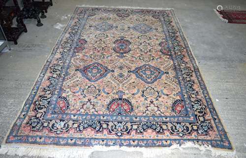 A LARGE PERSIAN MIDDLE EASTERN BLUE AND BEIGE GROUND CARPET decorated with motifs and foliage, by re