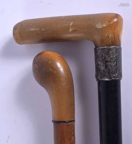 TWO 19TH CENTURY CONTINENTAL CARVED RHINOCEROS HORN HANDLED WALKING CANES one with silver mounts. 88