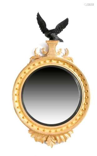 A LARGE GILTWOOD CONVEX WALL MIRROR IN REGENCY STY…