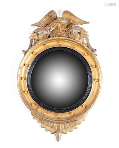 A GILTWOOD CONVEX WALL MIRROR IN REGENCY STYLE SEC…