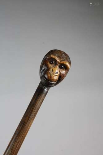 A CARVED WOOD WALKING CANE C.1920 the handle decor…