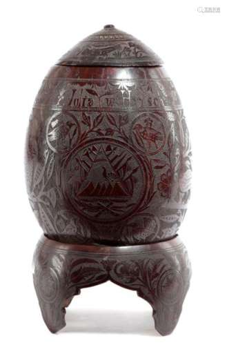 AN INDIAN CARVED COCONUT CUP AND COVER ON STAND 19…