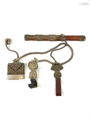 Tibetan knife, with wooden and silver plated metal handle and sheath, with an ornate metal chain and silver plated metal pendant chiselled with foliage and finished with a leather tongue. A Tibetan lighter is attached to it with its wrought metal belt and pendants. Length of the belt: 75 cm.