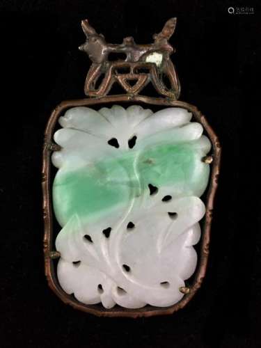 Pendant in light jadeite carved with fruits and flowered scrolls. Copper frame. Height 7 cm.