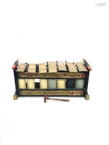 INDONESIA, slenthem in carved and painted wood with scroll decoration, bronze blades and resonance tubes in painted wood. Length: 89.5 cm. Width: 32 cm. Height: 42 cm. Wear and tear and accidents. A wooden and fabric mallet is attached.