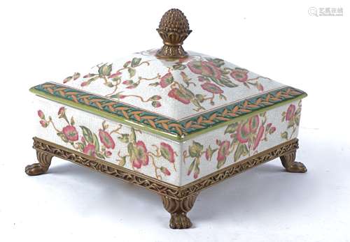 A Chinese box and cover raised on four lion's paw feet, with overglaze decoration of flowers and a