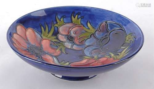 A Moorcroft pottery footed bowl with tube lined anemone design, the base with original retailer's