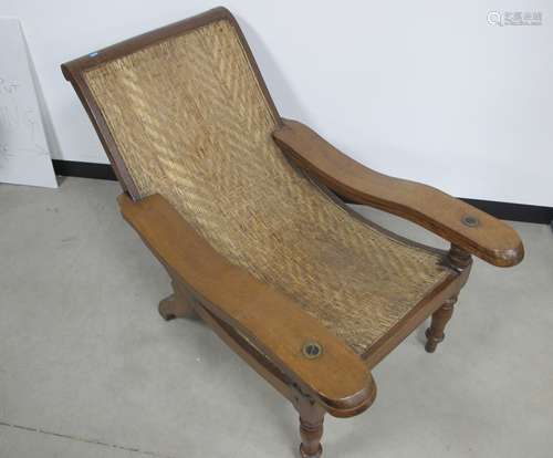 A 19th century teak Planters chair, rattan seat, working leg supports, raised on turned front