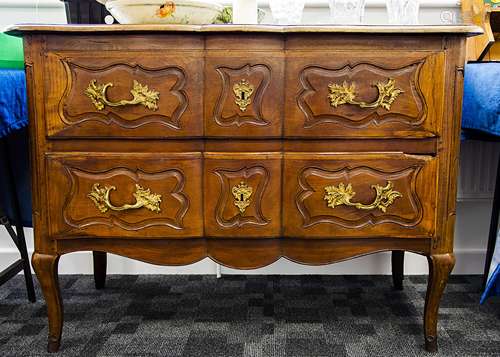 A continental walnut chest of drawers, the shaped moulded three panel section top over long drawer