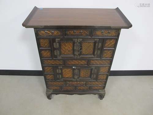 An oriental style hardwood side cabinet, three short drawers above two double doored cupboards faced