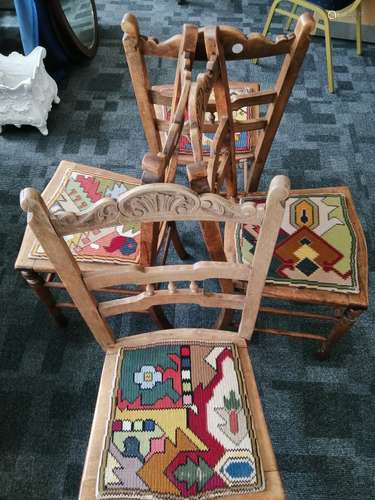 A set of four continental stained beech single dining chairs, with shaped back rails, carved crown