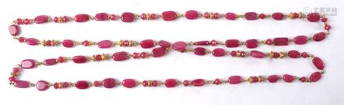 A necklace with semi precious red stones, some pebble lozenges and some multifaceted cuts, length