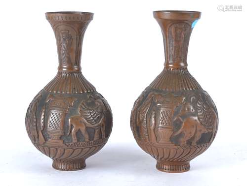 A pair of Middle Eastern copper vases with repousse work of figures attending upon a dignitary and