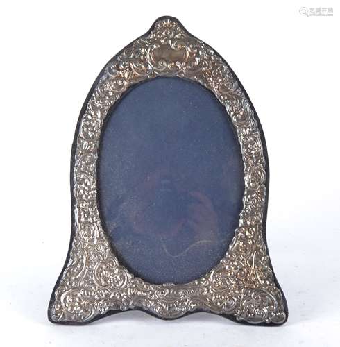 A silver mounted Elizabeth II frame of oval form surrounded by ornate scrolling decoration, London