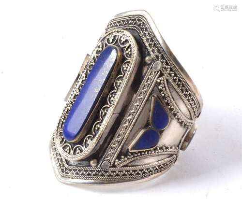 A lapis lazuli inset bangle, with various mounted cuts and decorative borders, height 9cm