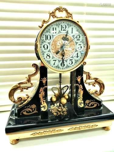 A 20th Century torsion pendulum mantle clock, metal dial with Arabic numerals, in a blue glazed